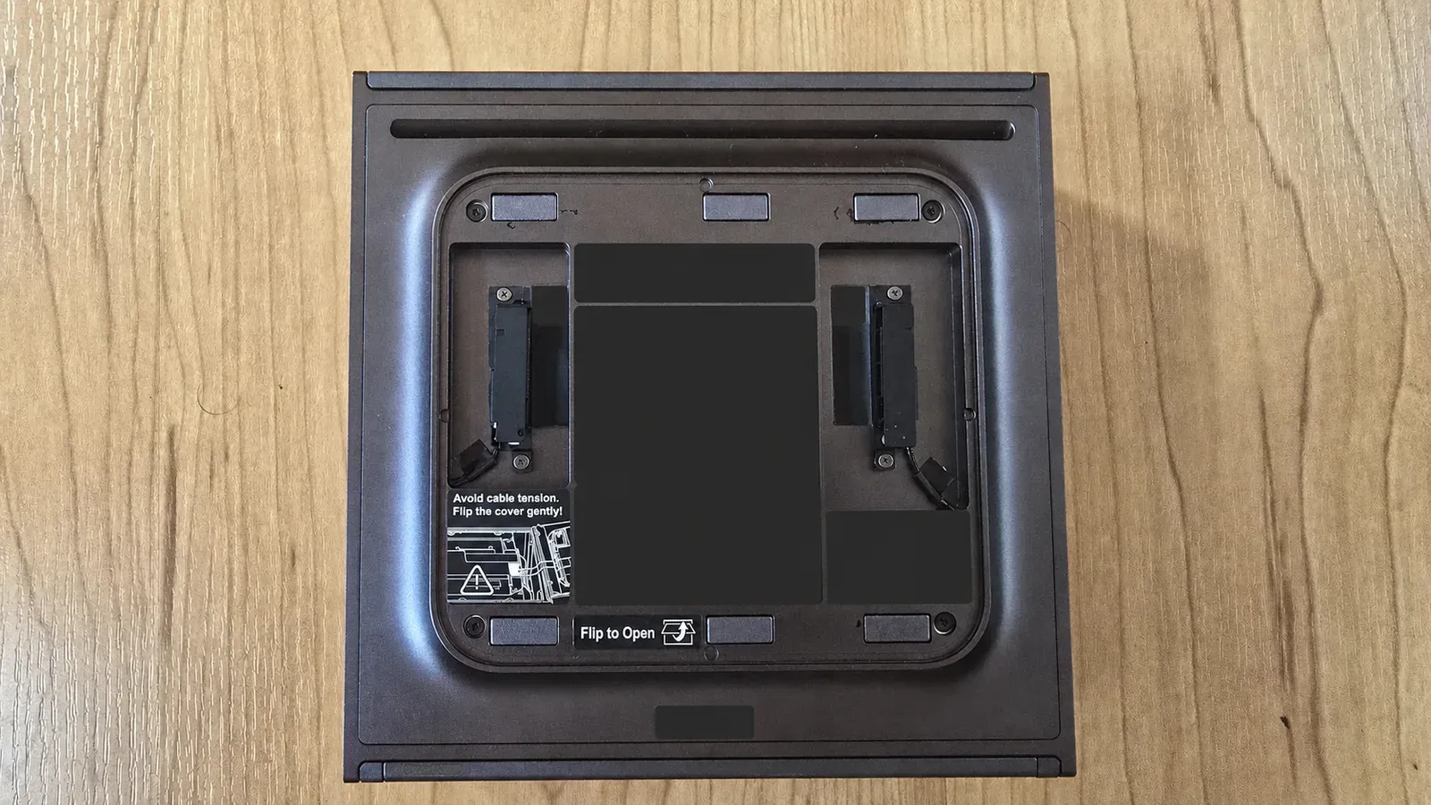 Bottom of the Dell Pro Max with GB10 after removal of the magnetic rubber base plate, showing the four Torx screws and cable-tension warning