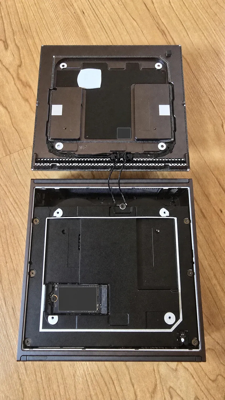 Dell Pro Max with GB10 bottom cover pivoted open, showing the attached antenna cables and accessible M.2 SSD